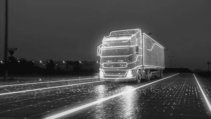 3D holographic truck with lights on the borders on an LED lit road | Featured Image for the ISO 42001 Certifications service landing page.