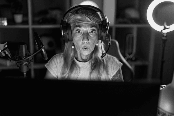 Older woman with shocked expression while wearing a headset and looking at a monitorImage | Featured Image for the NIST Cybersecurity Framework service page.