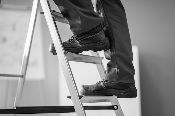 Someone on a step ladder, with each foot on a different step