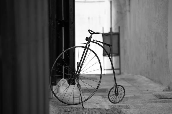 A penny farthing stationary in a side-street