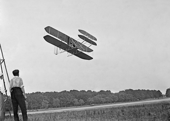 A man watching an air-plane fly over head